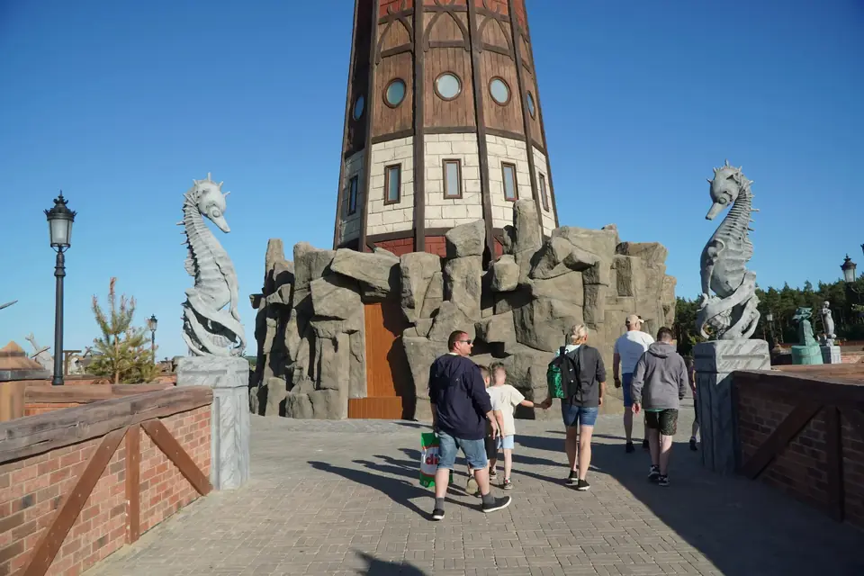 Centralny plac Hossoland z wieżą, rzeźbami strażników i odwiedzającymi