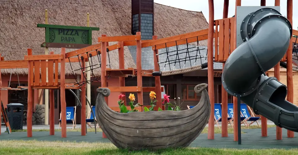 Aire de jeux avec un bateau viking et des éléments thématiques